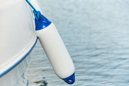 White fenders suspended between a boat and dockside for protection. Maritime fendersの写真素材