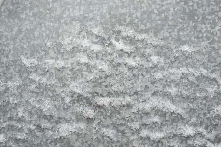 Zinc galvanized sheet of metal covered with ice snow. Can be used as background or texture