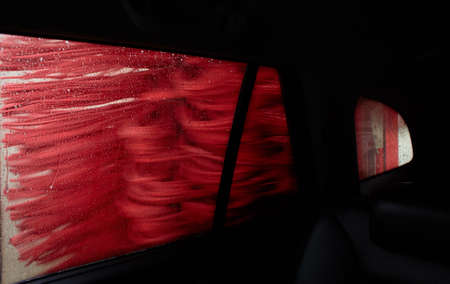 Car Care Business. Automatic Car Wash Process. Spray foam bubble shampoo on the car surface and Tire.の写真素材