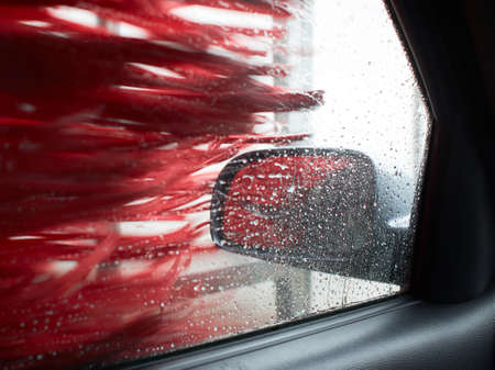 Car Care Business. Automatic Car Wash Process. Spray foam bubble shampoo on the car surface and Tire.の写真素材