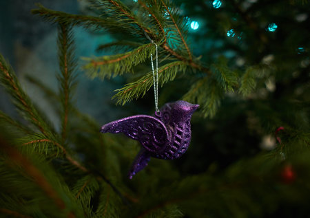 Close up of holiday electric blue garlands on fir branch with Christmas tree decoration and candy sweet. Candy cane hanging onto the branch of a Christmas treeの写真素材