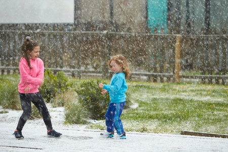 Dublin, Ireland - 04.10.2021: Kids is playing in the yard with first snow.のeditorial素材