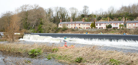 Dublin, Ireland - 03.19.2023: Healthy lifestyle kayaking in the Liffey River in Lucan. A group of kayakers go down on the waterfall. Recreational, relaxing, extreme sport activity.のeditorial素材
