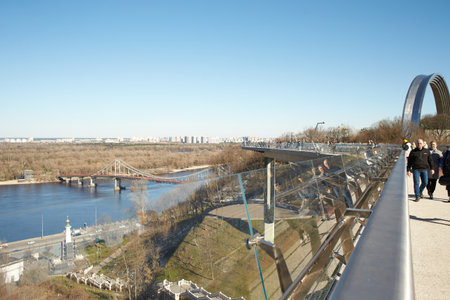 Kyiv, Ucraine-03.30.2023: Pedestrian and bicycle bridge across Saint Volodymyr descent in Kyiv, Ukraine. Glass Bridge, modern footbridge connecting historical centre of Kyiv with Aのeditorial素材