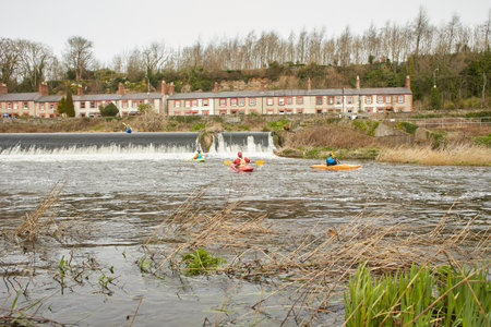 Dublin, Ireland - 03.19.2023: Healthy lifestyle kayaking in the Liffey River in Lucan. A group of kayakers go down on the waterfall. Recreational, relaxing, extreme sport activity.のeditorial素材