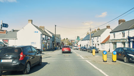 Portlaoise, Ireland - 03.04.2022: Rear view of cars driving on street road, Ireland. Road with metal safety barrier or rail. cars on the asphalt under the cloudy blue sky. Highwayのeditorial素材