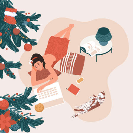 The girl lies and works at the laptop at home. Next to the cat and Christmas background. Freelancer, deadline, cozy office. Vector illustrationのイラスト素材