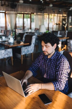 Man freelancer with laptop works in a cafeの写真素材