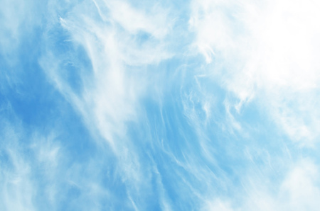 Blue sky with puffy white clouds in bright sunny dayの写真素材
