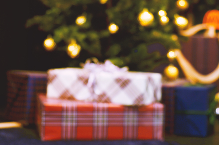 defocused light bokeh of christmas light tree. Gifts under the Christmas tree. Christmas presents  on Christmas Tree.の写真素材