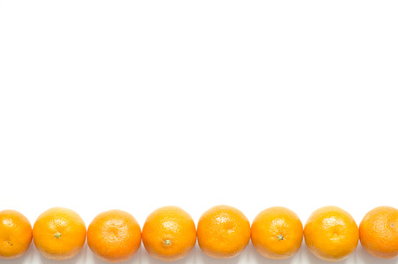 Mandarin oranges on white background. Citrus fruits with copy space. Frame from yellow mandarins. Top view and copy space.の写真素材