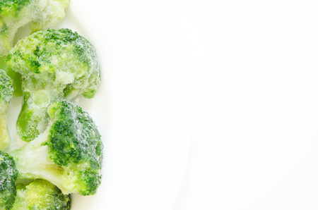 Frozen broccoli on a white plate. Top view, flat lay, copy space.の写真素材