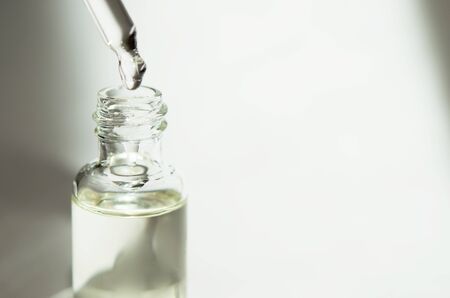Cosmetic or medical glass bottle with pipette on white background. Skin care concept. Natural hard...
