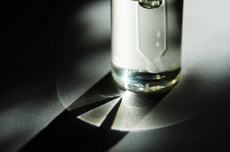 Cosmetic or medical glass bottle with pipette. Skin care concept. Natural hard light, deep shadows....