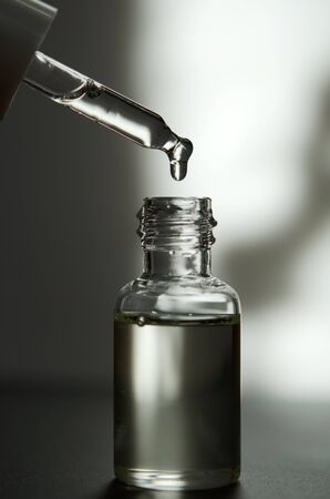 Cosmetic or medical glass bottle with pipette. Skin care concept. Natural hard light, deep shadows....
