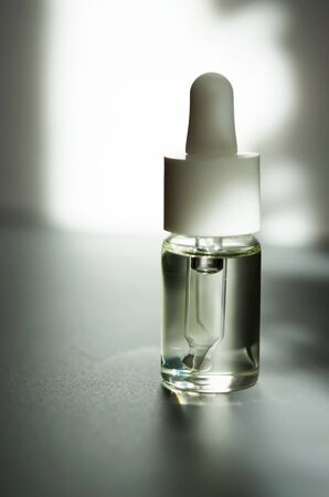 Cosmetic or medical glass bottle with pipette. Skin care concept. Natural hard light, deep shadows. - Imageの写真素材