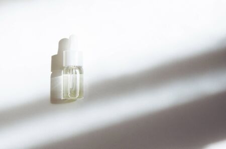Cosmetic or medical glass bottle with pipette on white background. Skin care concept. Natural hard...