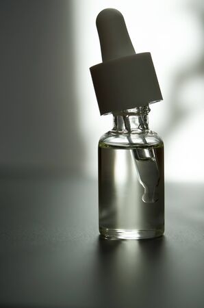 Cosmetic or medical glass bottle with pipette. Skin care concept. Natural hard light, deep shadows. - Imageの写真素材