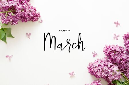 Inscription Happy March. Lilac flowers on white background. Spring flowers. Top view, flat lay. - Imageの写真素材