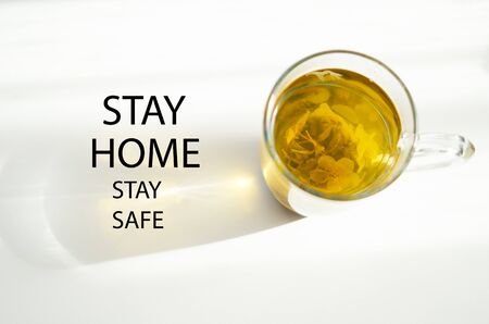 Stay at home and be safe. Self isolation and quarantine campaign to protect yourself and save lives. Herbal tea, shadow and sun rays.の写真素材