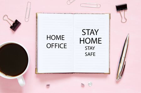 Home office. Stay home and stay safe. Self isolation and quarantine campaign to protect yourself and save lives. Workspace with notebook, stationery supplies and cup of coffee.の写真素材