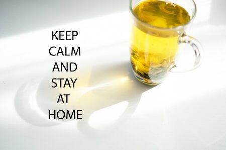 Keep calm and stay at home. Self isolation and quarantine campaign to protect yourself and save lives. Herbal tea, shadow and sun rays.の写真素材