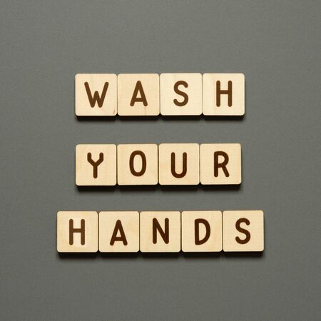 WASH YOUR HANDS - words from wooden blocks with letters. Top view on gray background. - Imageの写真素材