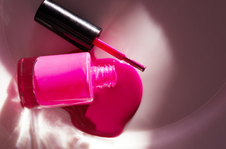 Pink nail polish dripping from bottle. Natural hard light, deep shadows. The concept of fashion and beauty industry. - Imageの写真素材
