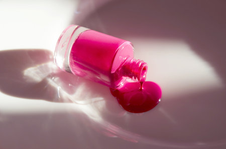 Pink nail polish dripping from bottle. Natural hard light, deep shadows. The concept of fashion and beauty industry. - Imageの写真素材