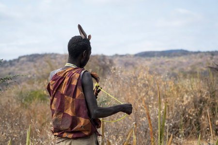 Rear view of a young man with earphones in the field