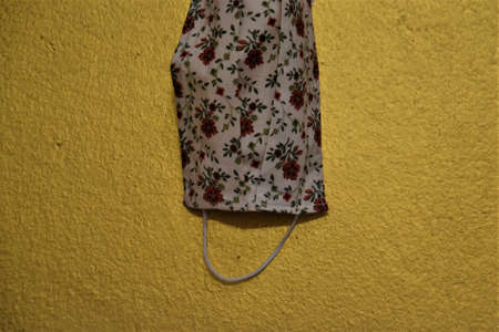Medical face mask hanging on a gold wall, Corona, Covid19, worldwide pandemic