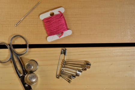 Tools and accessories for sewing on light wooden background. Place for textの写真素材