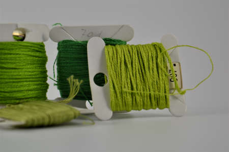 Colorful green tone thread spools isolated on a white