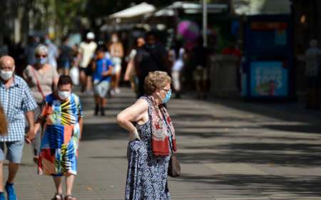 Barcelona, Spain, August 9, 2020: Old woman walking around wearing protective medical masks to prevent virus Covid-19 in Barcelona, Spain, Europe. Tourist spots in the covid eraのeditorial素材
