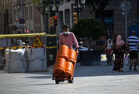 Barcelona, Spain, August 9, 2020: Tank delivery man wearing protective medical masks to prevent virus Covid-19 in Barcelona, Spain, Europe. Tourist spots in the covid eraのeditorial素材