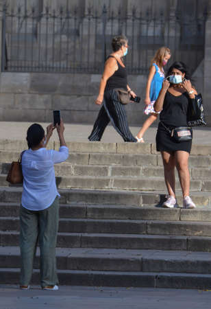 Barcelona, Spain, August 24, 2020: Caucasian woman taking a picture wearing protective covid-19 face mask. Touristy spots in the covid eraのeditorial素材