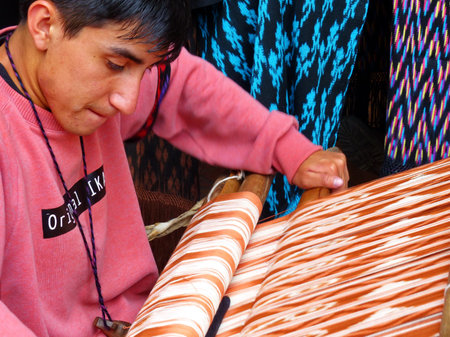 Cuenca, Ecuador - March 8, 2019: Ecuadorian man is weaving scarf or Macana by hand with cotton threads, design and technique IKAT are traditional for Gualaceo canton, Azuay province of Ecuadorのeditorial素材