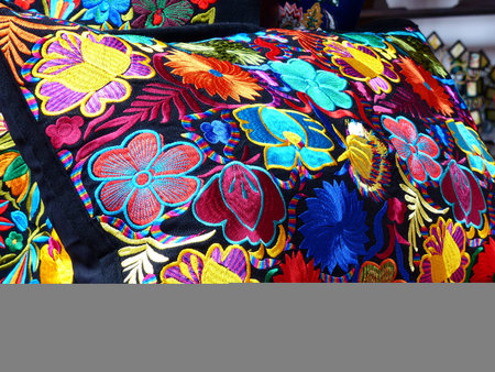 Close up of Ñolorful embroidered decorative textile and pillows from Otavalo city at the artisans...
