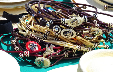 Pile of hat bands for Peruvian Paso style straw Panama hats with horse head as element of design
