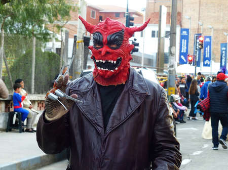 Cuenca, Ecuador - January 6, 2020: Traditional parade or masquerade on Day of the Innocents. Man in red mask of Devilのeditorial素材