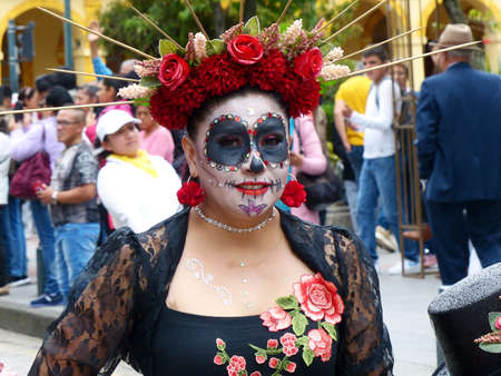 Cuenca, Ecuador - November 5, 2019: Traditional parade on day of independence of Cuenca. Beautiful dressed up woman has dreadful face makeup as Zombieのeditorial素材