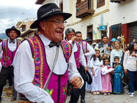 Ð¡uenca, Ecuador - December 24, 2019: Christmas parade Pase del Nino Viajero (Traveling Child). Senior man with group of dancers as participants of parade. Event is intangible heritage of UNESCOのeditorial素材