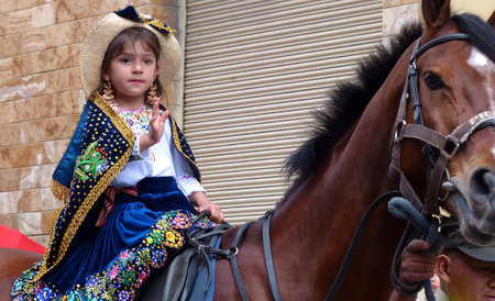 Cuenca, Ecuador-December 24,2019: Christmas parade Pase del Nino Viajero (Traveling Child). Little girl dressed up for parade in embroidered clothes riding horse. Event is intangible heritage UNESCO.のeditorial素材