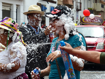 Cuenca, Ecuador - February 22, 2020: Carnival parade in Cuenca city.  Citizens celebrate Carnival at main square. People have fun and traditionally spray foam on everyone.のeditorial素材
