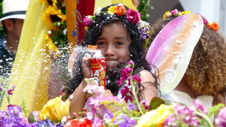 Cuenca, Ecuador - February 22, 2020: Annual carnival parade in Cuenca city. Little cute girl with can of spray having fun during parde spraying foam to audience. Tradition way to celebrate carnivalのeditorial素材