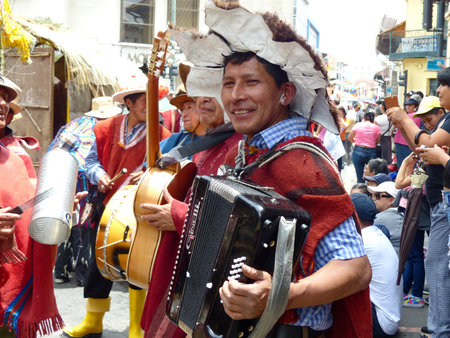 Cuenca, Ecuador - February 22, 2020: Carnival parade in Cuenca city. Indigenous village musician men playing accordion, guitar, big drum at the parade during. Azuay province, Ecuador.のeditorial素材