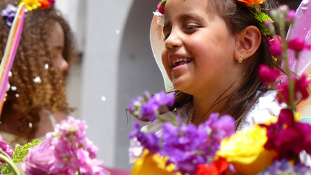 Cuenca, Ecuador-February 22, 2020: Annual carnival parade in Cuenca city. Little cute girl  has fun during parade. Drops of spraying foam are in the air. Tradition way to celebrate carnival in Ecuadorのeditorial素材