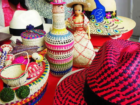 Cuenca, Ecuador-March 31, 2021: Wicker souvenirs: baskets, dolls, bottles, vases, hats made from toquilla straw, vegetable fiber, and painted with various colors at artisan market in Cuenca, Ecuadorのeditorial素材