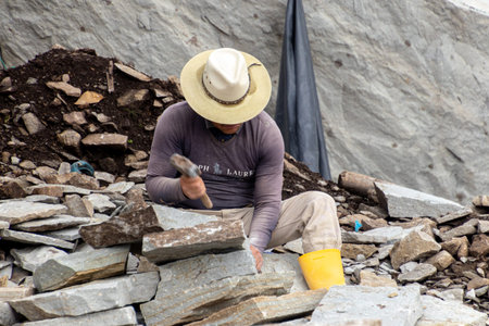 Azogues, Ecuador - February 22, 2022: Village man works in a quarry manually processing stones for...