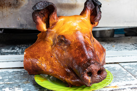 Head of big roasted pig is ready to eat at the food market in Cuenca. Traditional food and the way to cook pigs in Ecuadorの写真素材